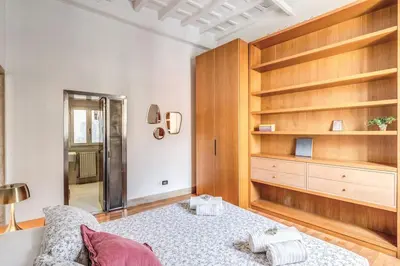 a bedroom with a bed and wooden shelves at Trastevere at Piazza Giuditta Arcuati suite in Rome