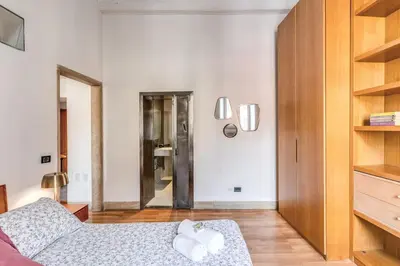 a white room with a bed and a mirror at Trastevere at Piazza Giuditta Arcuati suite in Rome