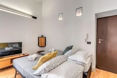 a bedroom with a bed and a flat screen tv at Trastevere at Piazza Giuditta Arcuati suite in Rome