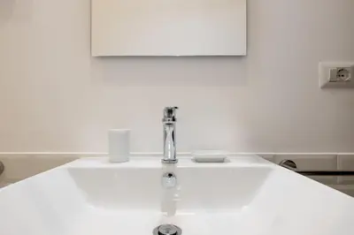 a white bathroom sink with a faucet at Adriana Star luxury large and central in Rome