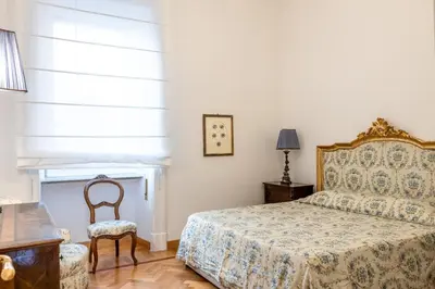 a bedroom with a bed and a chair and a window at Adriana Star luxury large and central in Rome