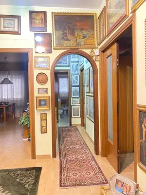 a hallway with an archway in a building with paintings on the walls at Room near San Pietro and Vaticano in Rome