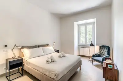 a bedroom with a bed and a blue chair at Via Provana San Giovanni 2 bedroom apartment in Rome