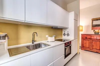 a kitchen with white cabinets and a sink at Via Provana San Giovanni 2 bedroom apartment in Rome