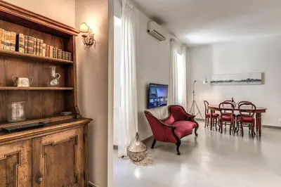 a living room with red chairs and a table at Via Provana San Giovanni 2 bedroom apartment in Rome