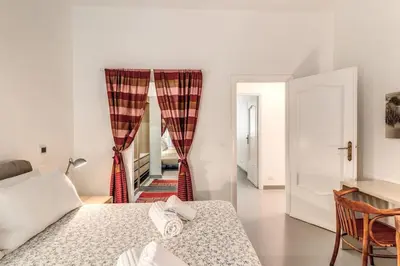 a bedroom with a bed and curtains in a room at Via Provana San Giovanni 2 bedroom apartment in Rome