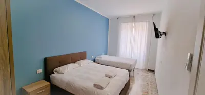 a bedroom with two beds and a blue wall at Rome Aparts - Deluxe Apartment with 3 bedrooms at St Peter square in Rome