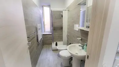 a white bathroom with a toilet and a sink at Rome Aparts - Deluxe Apartment with 3 bedrooms at St Peter square in Rome