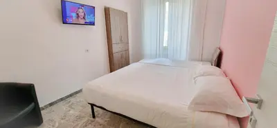 a small bedroom with a bed and a tv on the wall at Rome Aparts - Deluxe Apartment with 3 bedrooms at St Peter square in Rome