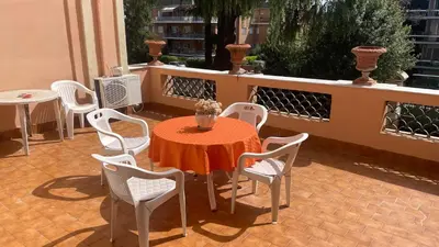 a table with white chairs and a orange table and chairs at La Villa di Roma in Rome