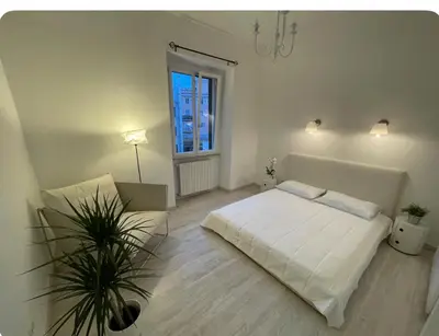 a white bedroom with a bed and a window at Colosseum Lindarella Home in Rome
