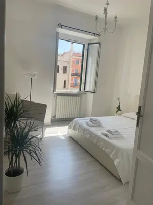 a white bedroom with a bed and a window at Colosseum Lindarella Home in Rome