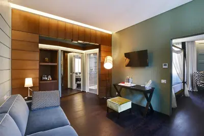 a living room with a blue couch and a desk at Stendhal Luxury Suites in Rome