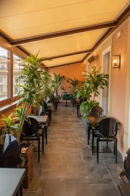 a corridor of a restaurant with tables and plants at Stendhal Luxury Suites in Rome