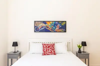 a bedroom with a white bed and two night stands at iFlat Vatican Elegant and Spacious Apartment in Rome