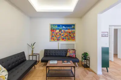 a living room with a couch and a painting on the wall at iFlat Vatican Elegant and Spacious Apartment in Rome