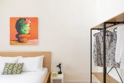 a bedroom with a bed and a cactus painting on the wall at iFlat Vatican Elegant and Spacious Apartment in Rome