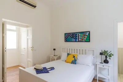 a bedroom with a white bed with a hat on it at iFlat Vatican Elegant and Spacious Apartment in Rome
