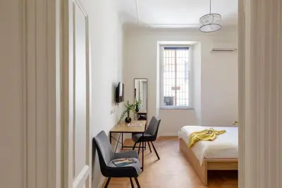 a bedroom with a bed and a table and chairs at iFlat Vatican Elegant and Spacious Apartment in Rome