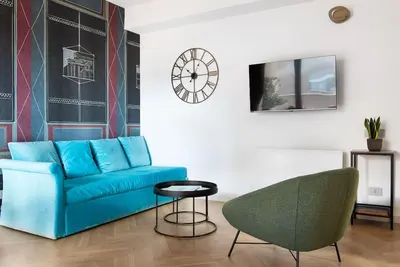 a living room with a blue couch and a chair at Idyllia - Maia luxury apartment in Rome