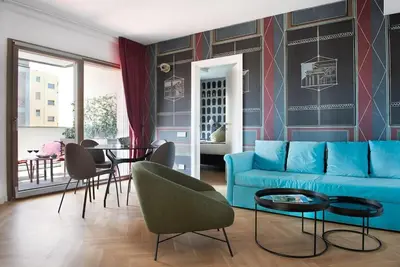a living room with a blue couch and a table at Idyllia - Maia luxury apartment in Rome
