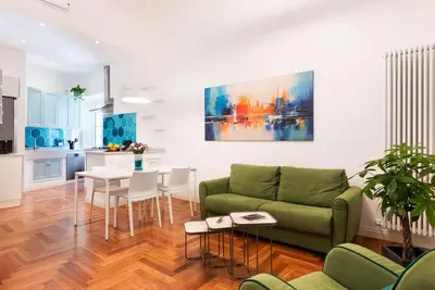 a living room with a green couch and a table at Idyllia - Vatican Stylish Flat in Rome