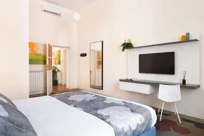 a bedroom with a bed and a tv on a wall at Idyllia - Vatican Stylish Flat in Rome
