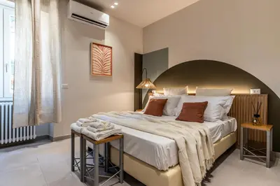 a bedroom with a large bed with a large headboard at Dafne room Nido perfetto per coppie a Roma in Rome