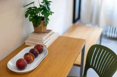 a plate of apples on a wooden table with a plant at Dafne room Nido perfetto per coppie a Roma in Rome