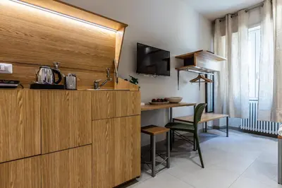 a kitchen with a sink and a desk in a room at Dafne room Nido perfetto per coppie a Roma in Rome