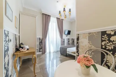 a room with a bed and a table with a vase of flowers at Le Chiavi di Roma in Rome