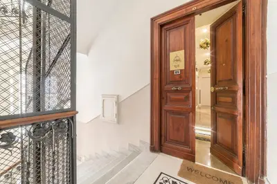 a hallway with a wooden door and stairs at Le Chiavi di Roma in Rome