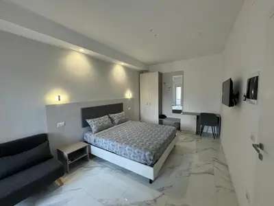 a bedroom with a bed and a couch and a desk at Alba White in Rome