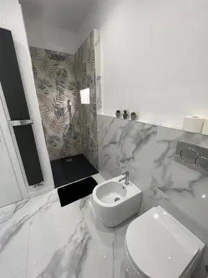 a white bathroom with a toilet and a sink at Alba White in Rome