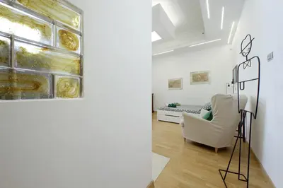 a living room with a white chair and a painting at Delizioso loft all'Esquilino in Rome