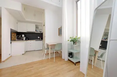a kitchen with white cabinets and a table and chairs at Delizioso loft all'Esquilino in Rome