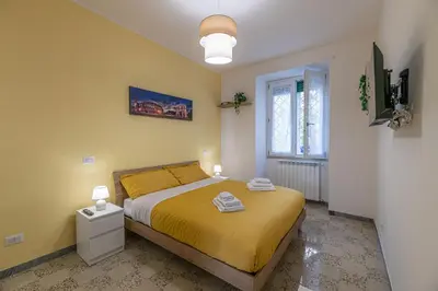 a bedroom with a bed with yellow sheets and a window at DOMVS Quattro Venti in Rome