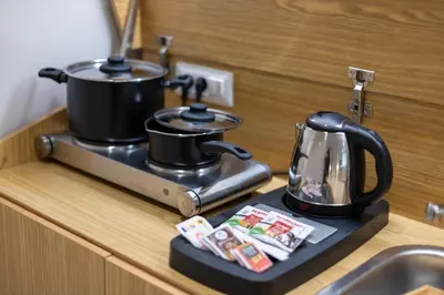 a stove with two pots and a tea kettle on it at Dafne room Ampio nido, vera promessa di relax in Rome
