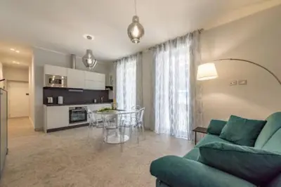 a living room with a green couch and a kitchen at Heavenly Trevi Luxury Apartment in Rome