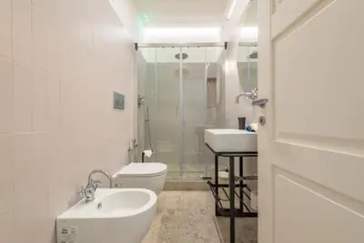 a white bathroom with a toilet and a sink at Heavenly Trevi Luxury Apartment in Rome