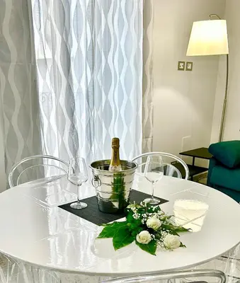 a white table with a bottle of wine and flowers at Heavenly Trevi Luxury Apartment in Rome