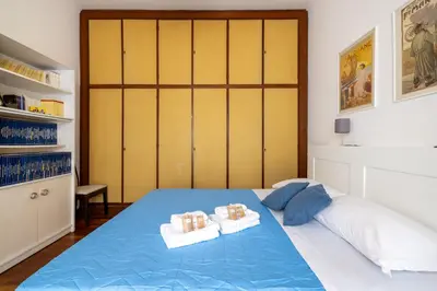 a bedroom with a blue bed with two towels at Aurelia Dream with Terrace in Rome