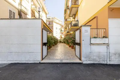 an alley between two buildings with doors and plants at Aurelia Dream with Terrace in Rome
