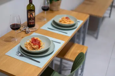 a table with two plates of pasta and a bottle of wine at Dafne room Speciale, elegante con balcone in Rome