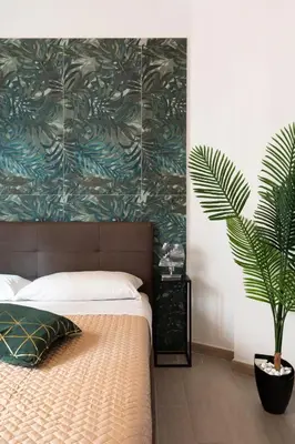 a bedroom with a bed with a plant next to it at Ginny in Trastevere in Rome