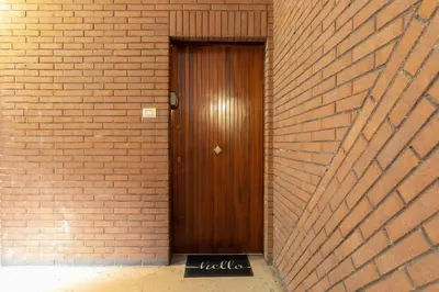 a wooden door in a brick wall at Ginny in Trastevere in Rome