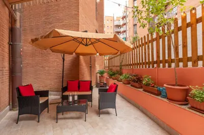 a patio with a table and chairs and an umbrella at Ginny in Trastevere in Rome