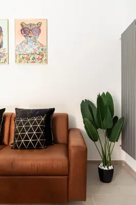 a brown couch in a living room with a plant at Ginny in Trastevere in Rome