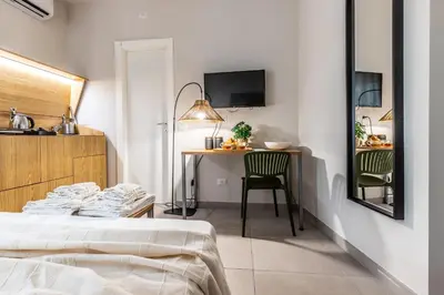 a bedroom with a bed and a table with a chair at Dafne room Un'oasi romana per coppie in Rome