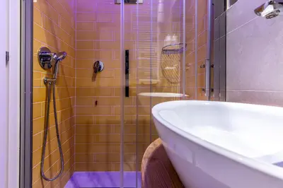 a bathroom with a shower with a tub and a sink at Dafne room Un'oasi romana per coppie in Rome